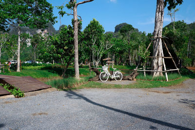 Bicycles on footpath by road against sky