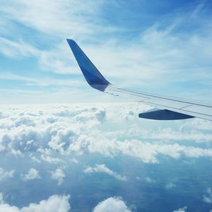 Low angle view of airplane flying against cloudy sky