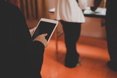 Midsection of man using digital tablet