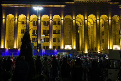 Group of people in illuminated city at night