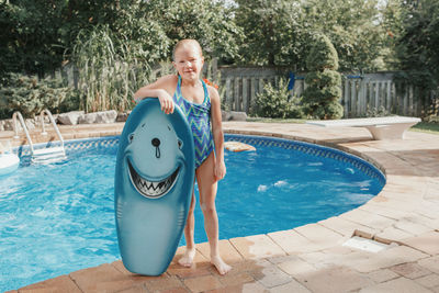 Woman standing by swimming pool