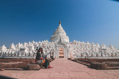 Tourists at temple against buildings