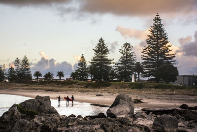 People standing on rock against sky