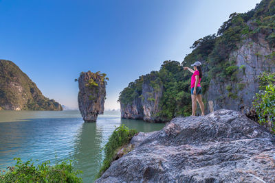 Woman man standing by sea on rock