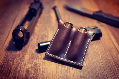 Close-up of bullets with gun on wooden table