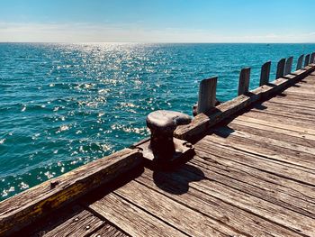 Wooden pier over sea against sky