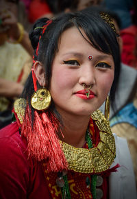 Close-up portrait of young woman with make-up and jewelry