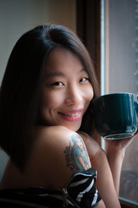 Close-up portrait of smiling woman sitting outdoors