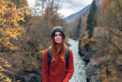 Portrait of smiling young woman standing during autumn