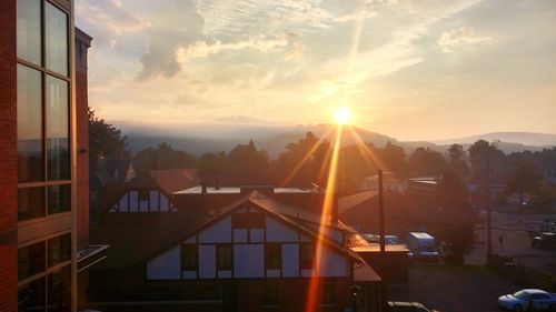 Houses and buildings against sky during sunset