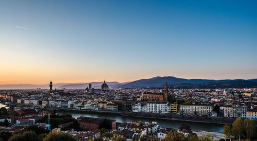 High angle view of city at river during sunset