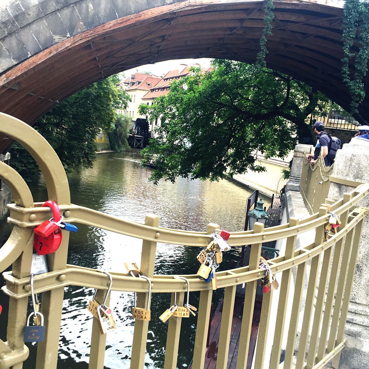 water, railing, built structure, architecture, river, bridge - man made structure, day, connection, transportation, nautical vessel, tree, outdoors, wood - material, high angle view, building exterior, nature, canal, boat, tourism, footbridge