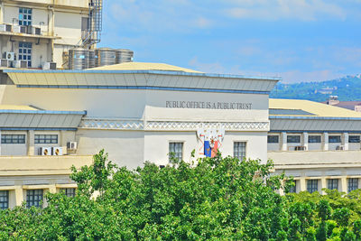 Plants and buildings against sky