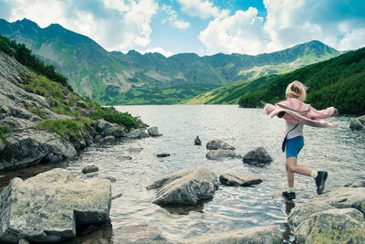 Full length of girl jumping at lake