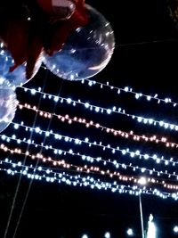 Low angle view of illuminated christmas lights at night