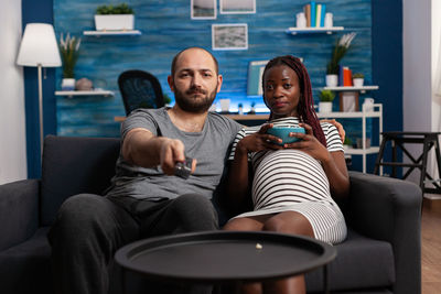 Young couple sitting on sofa at home