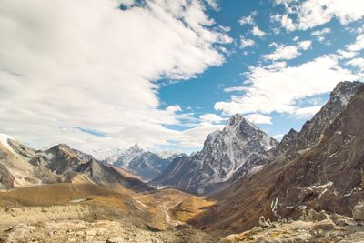 Scenic view of snowcapped mountains against cloudy sky