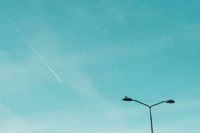 Low angle view of street light against blue sky