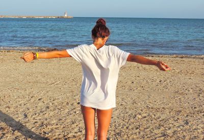 Rear view of woman standing on beach