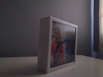 Reflection of man photographing on table at home