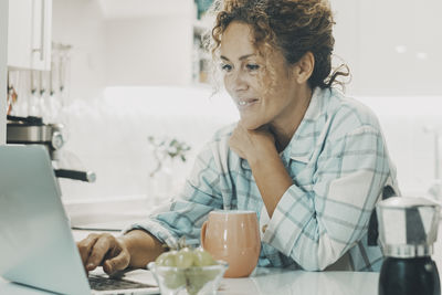 Female friends using laptop at home