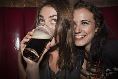 Portrait of a smiling young woman drinking glass