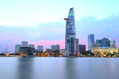 Illuminated buildings in city against sky