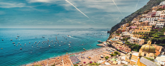 High angle view of townscape by sea against sky