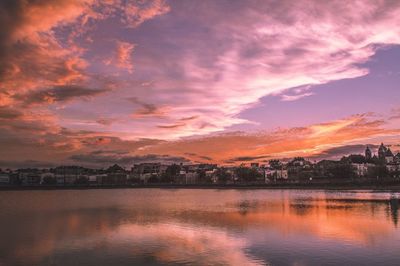 Scenic view of river against cloudy sky at sunset