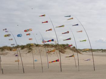 Low angle view of flags on beach against sky