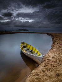 Boat moored on sea shore against sky