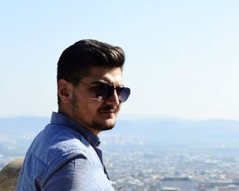 Portrait of young man wearing sunglasses against sky