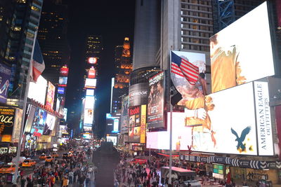 High angle view of people on street amidst buildings at night