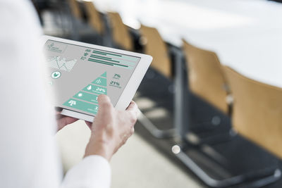 Businesswoman in conference room using tablet with data