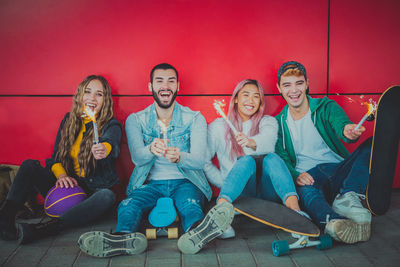 Happy young people happiness outdoors with streamers - group of cheerful teenagers having fun time