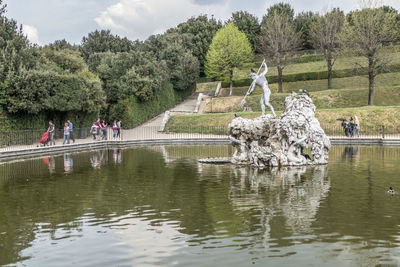 People in lake by trees