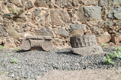 Stone wall by rocks on land