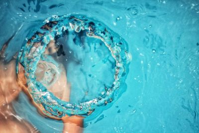 Close-up of person swimming in blue pool