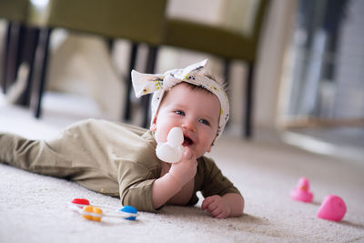 Cute baby girl lying on bed at home