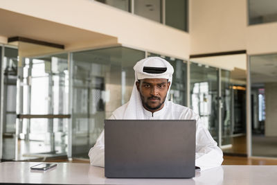 Portrait of woman using laptop at home