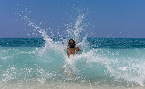 Little kid enjoying the waves on the beach