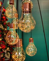 Close-up of illuminated light bulbs hanging on ceiling