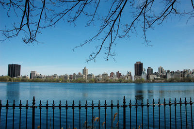 Scenic view of river by buildings against sky