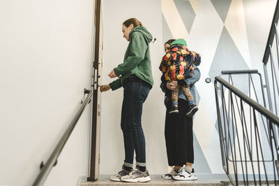 Women with daughter opening apartment door