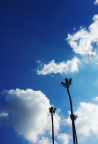 Low angle view of trees against cloudy sky