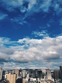Buildings against cloudy sky