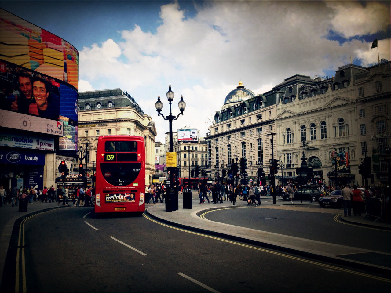 building exterior, architecture, transportation, street, built structure, car, land vehicle, city, sky, mode of transport, road, city street, city life, cloud - sky, incidental people, traffic, cloud, road marking, building, the way forward