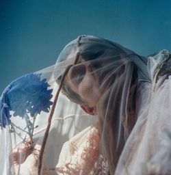 Portrait of man with flowers wearing textile against clear sky