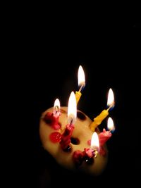 Close-up of lit candles in darkroom