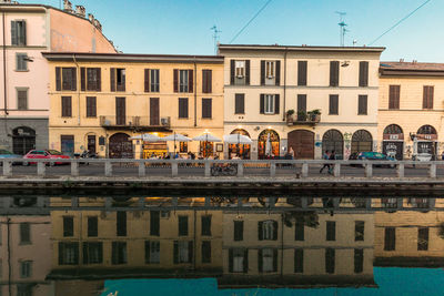 Building by river against sky in city